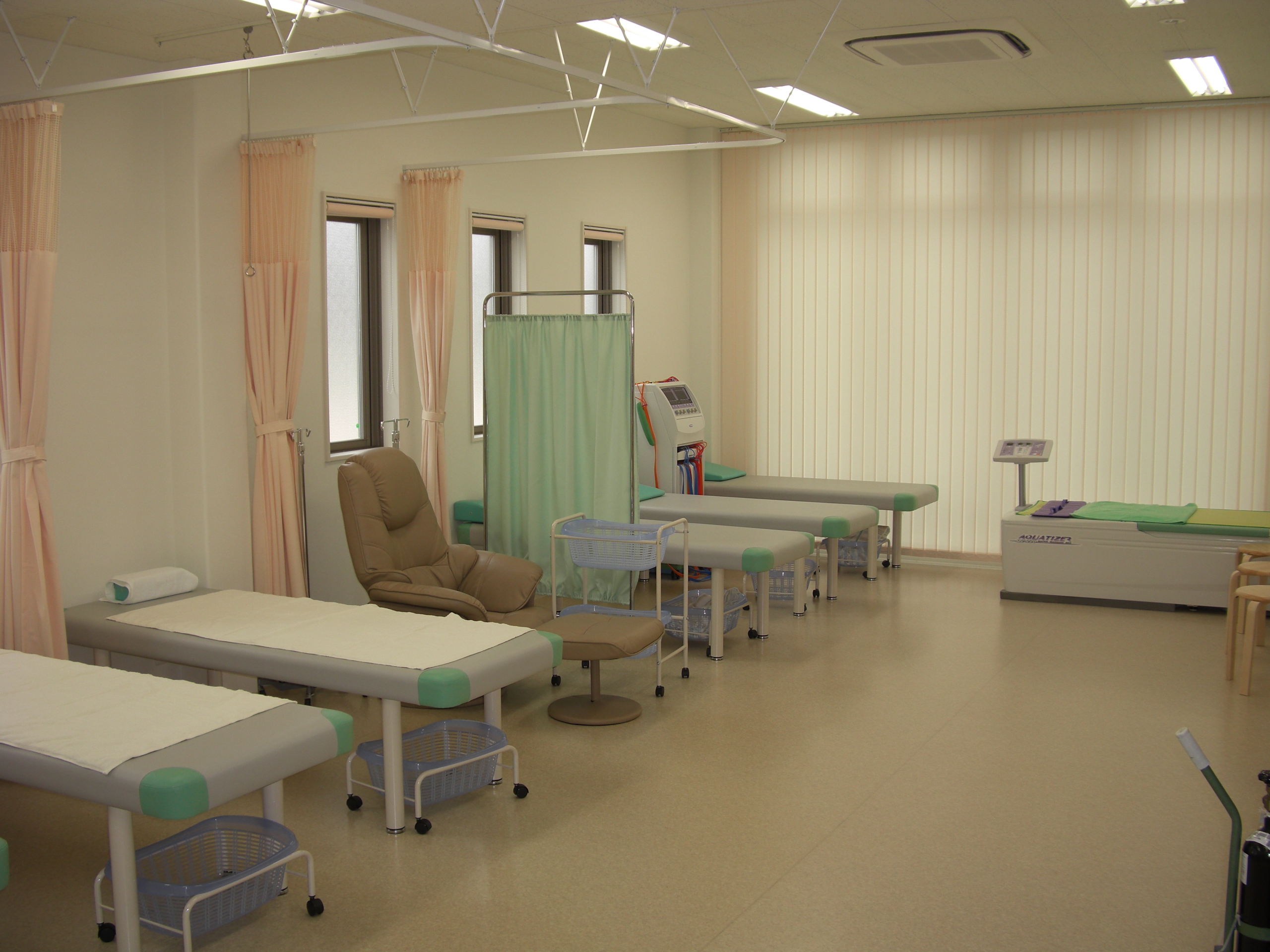 処置室・リハビリテーション室　　明るく広々とした空間は患者様のプライバシーを守りながらも、医師・看護師がそばにいる安心感を与えます